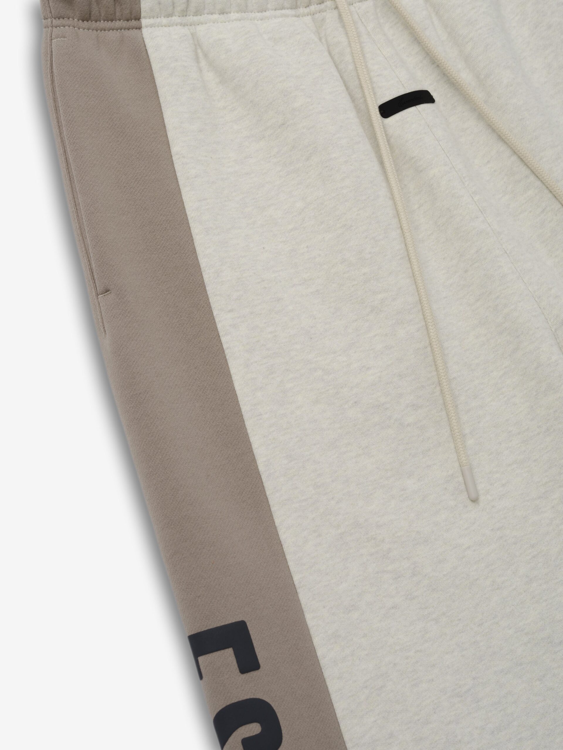 RW00285_PANELLED_RAW_CUT_OFF_SWEATPANT-VANILLA_HEATHER_SEAL_3_24a54cd6-a7c5-47f6-90a2-b39c168a3fb8.jpg Fear of God Essentials Panelled Raw Cut Off Sweatpant Vanilla Heather / Seal